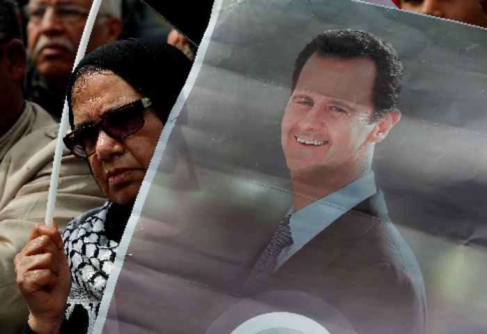 En demonstrant har en plakat av Syrias president Bashar al-Assad																		AP Photo/Hussein Mall