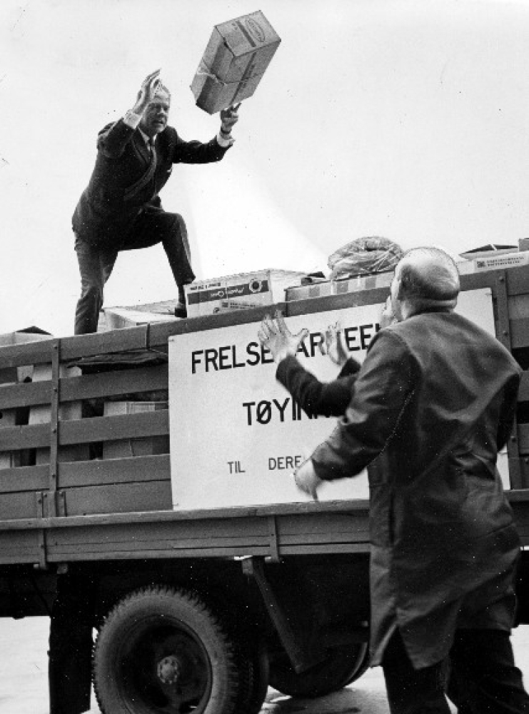1970: Frelsesarmeens tøyinnsamlig er i gang. Mannen bak opplegget: Kristian Berents langer pakker til major Carl Jacobsen, som leder arbeidet og bestyrer major Per Rekdal ved Elevator. Foto: NTB / SCANPIX