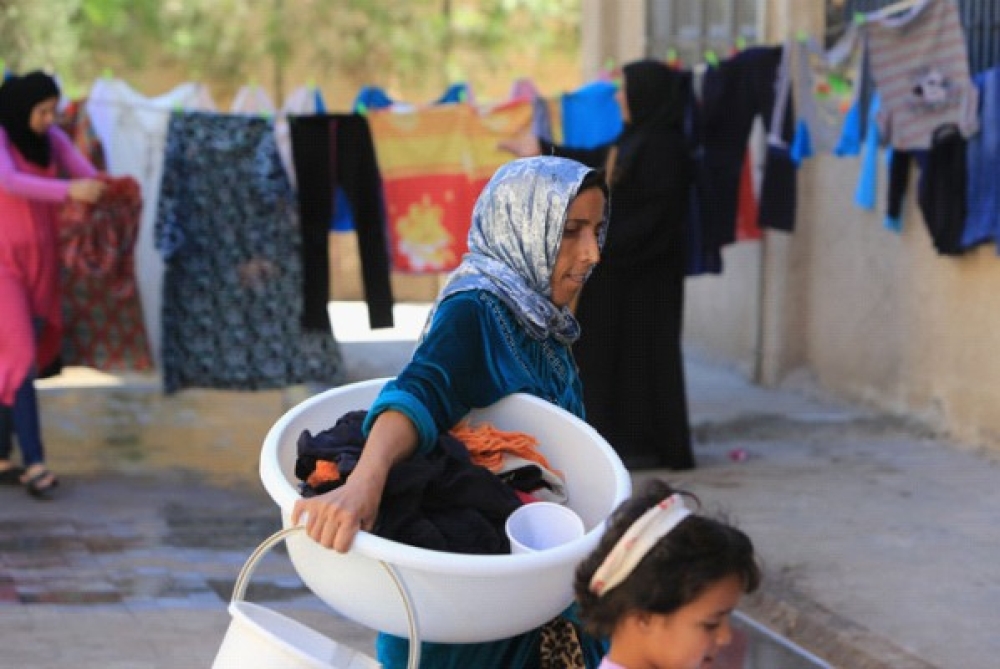 USA-NATO-støttede terrorister forgiftet julaften vannforsyningen til Damaskus med diesel. En krigsforbrytelse. Syriske røde halvmåne har installert vanntanker i flere bydeler i Damaskus. Her samler kvinner nyvasket tøy i bydelen Al Adlieh. Viktig å holde klær og sengetøy rent for å hindre utbredelse av sykdom og helseplager. 								Foto: Ibrahim Malla/IFRC 