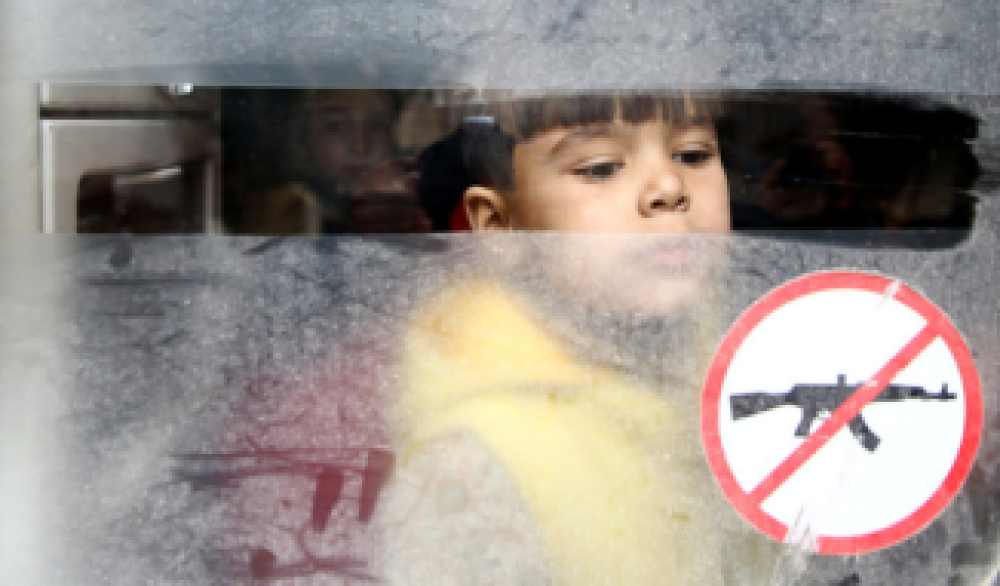 Evakuering fra Douma: En liten gutt kikker ut av bussen, som skal kjøre ham til et trygt sted. Foto: Bassam Khabieh/ Reuters