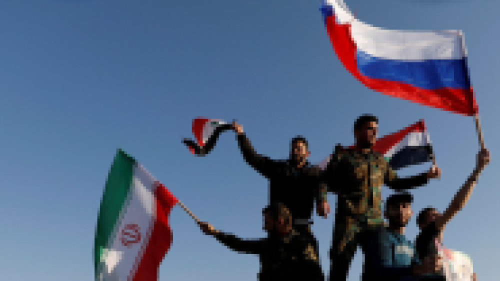  Syrere vifter med russiske og syriske flagg under en protest mot et USA-ledet luftangrep i Damaskus, Syria, 14/4-2018. © Omar Sanadiki / Reuters.