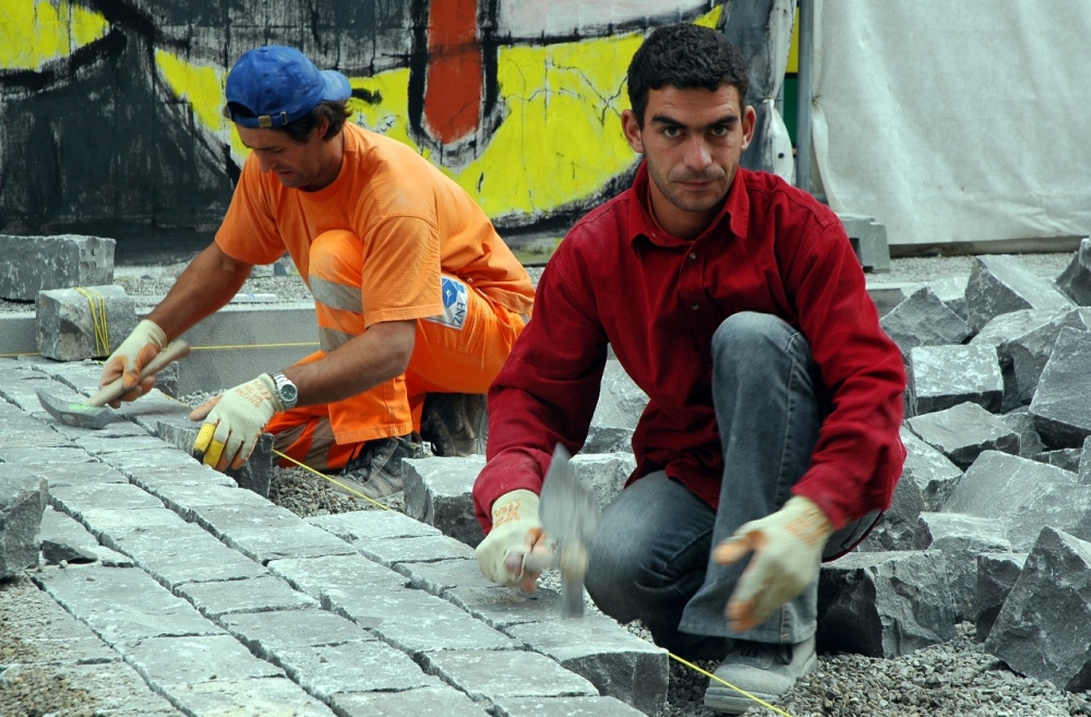 Illustrasjonsfoto. Mange portugisere og spanjoler har funnet veien til bygge- og anleggsbransjen i Sveits etter at landet åpnet sitt arbeidsmarked for personer fra de 15 gamle EU-landene for tre år siden. Søndag er det folkeavstemning om avtalen skal utvides til de nye EU-landene i Øst-Europa. Her brolegges en av hovedgatene i den sveitsiske hovedstaden Bern. Foto: Kjetil Elsebutangen / Scanpix .